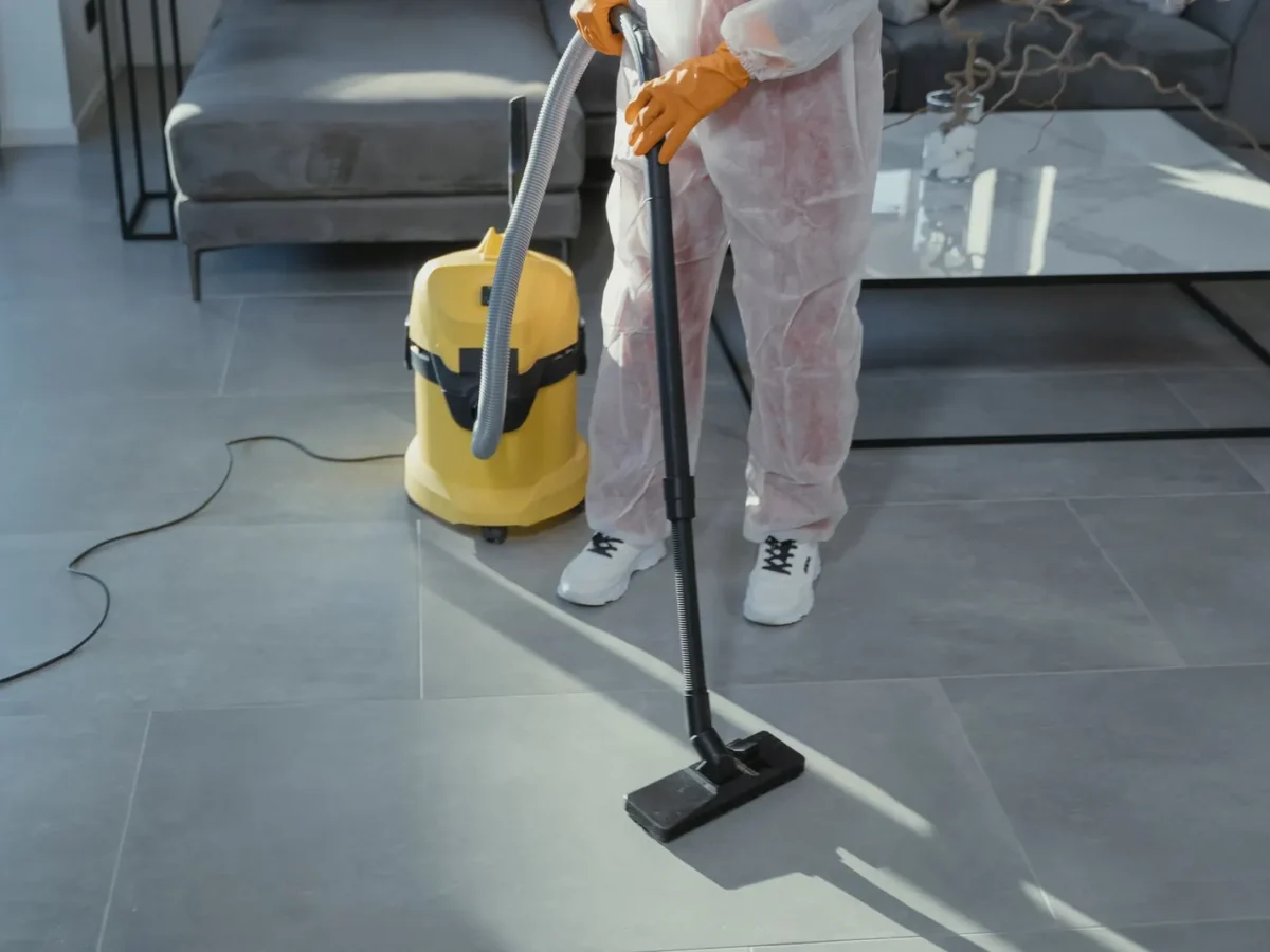 Professional cleaner vacuuming a living room