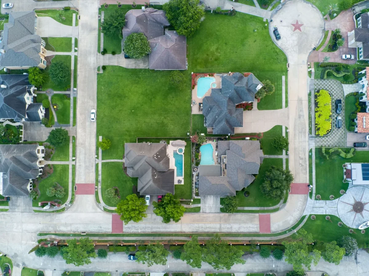 Aerial view of suburban homes with pools near Houston