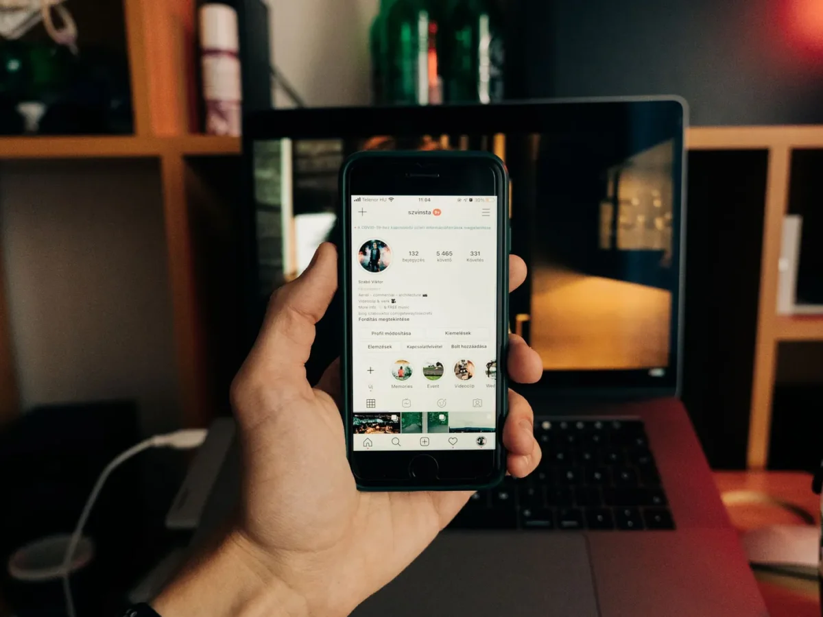 Hand holding a phone with an Instagram profile open