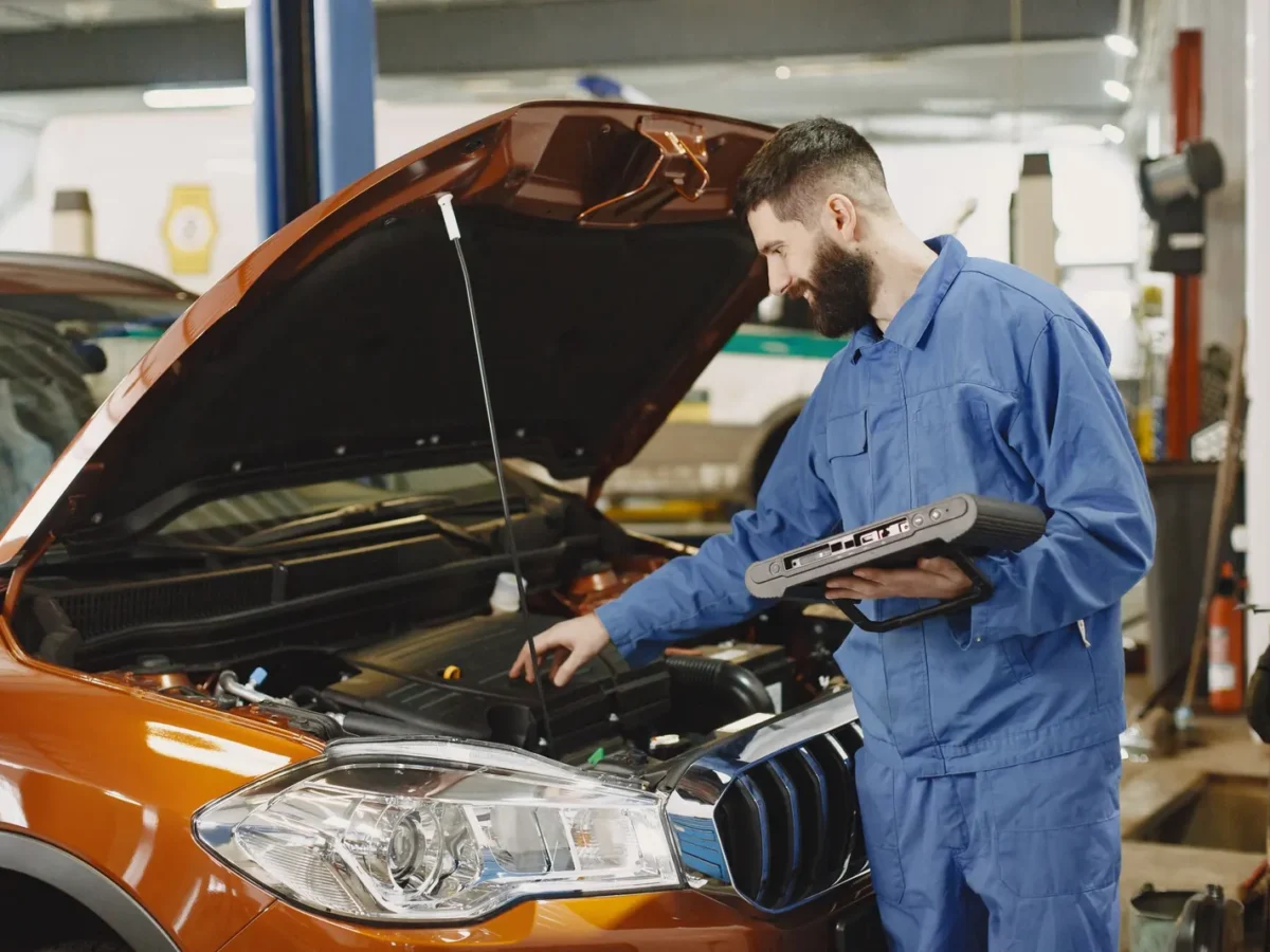 Mechanic checking a car engine in a repair shop