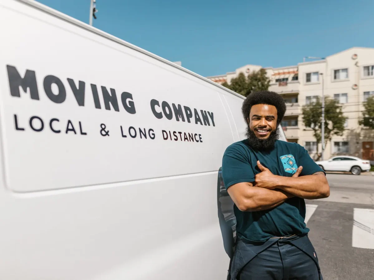 Mover standing beside a moving company van