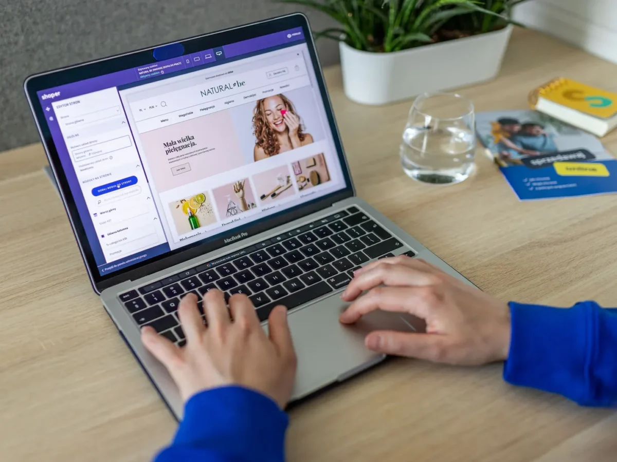 Hands typing on a laptop with an online store open