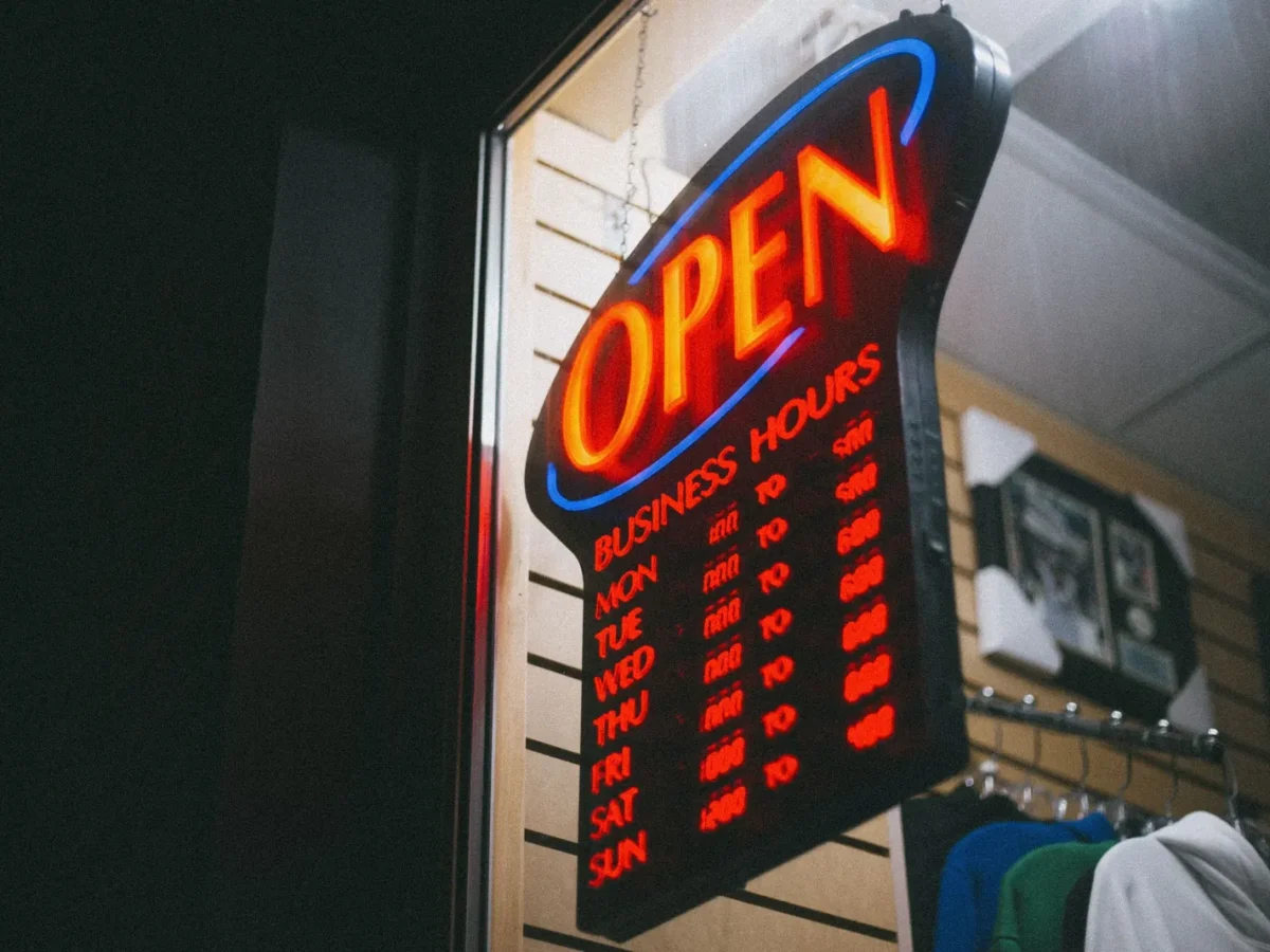 Neon open sign with business hours in a shop window