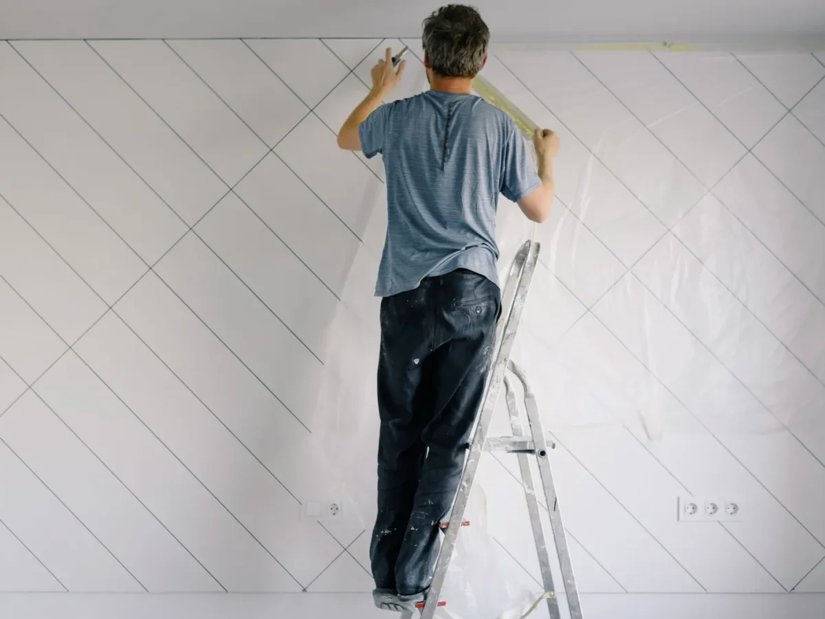 Painter priming a wall in a bright room