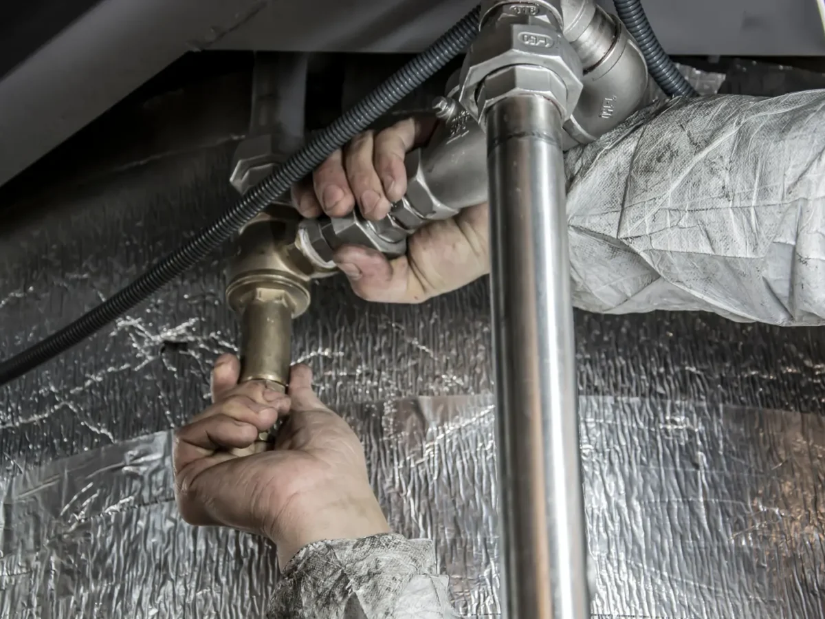 Plumber's hands tightening steel pipe fittings