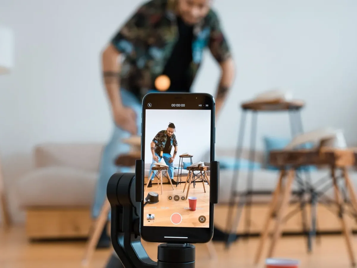 Man recording a short video on a phone mounted on a tripod