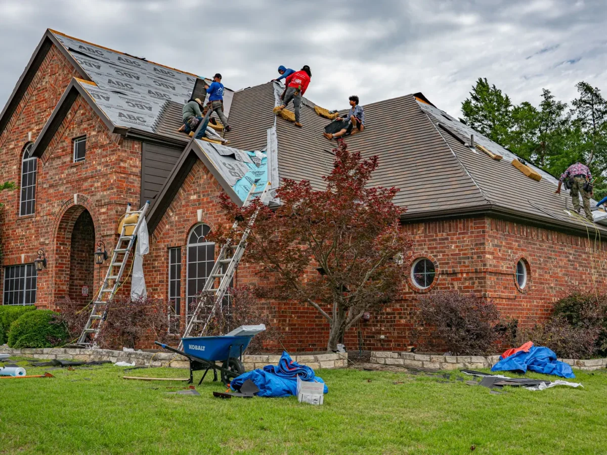Roofers replacing shingles on a brick home in Allen, Texas
