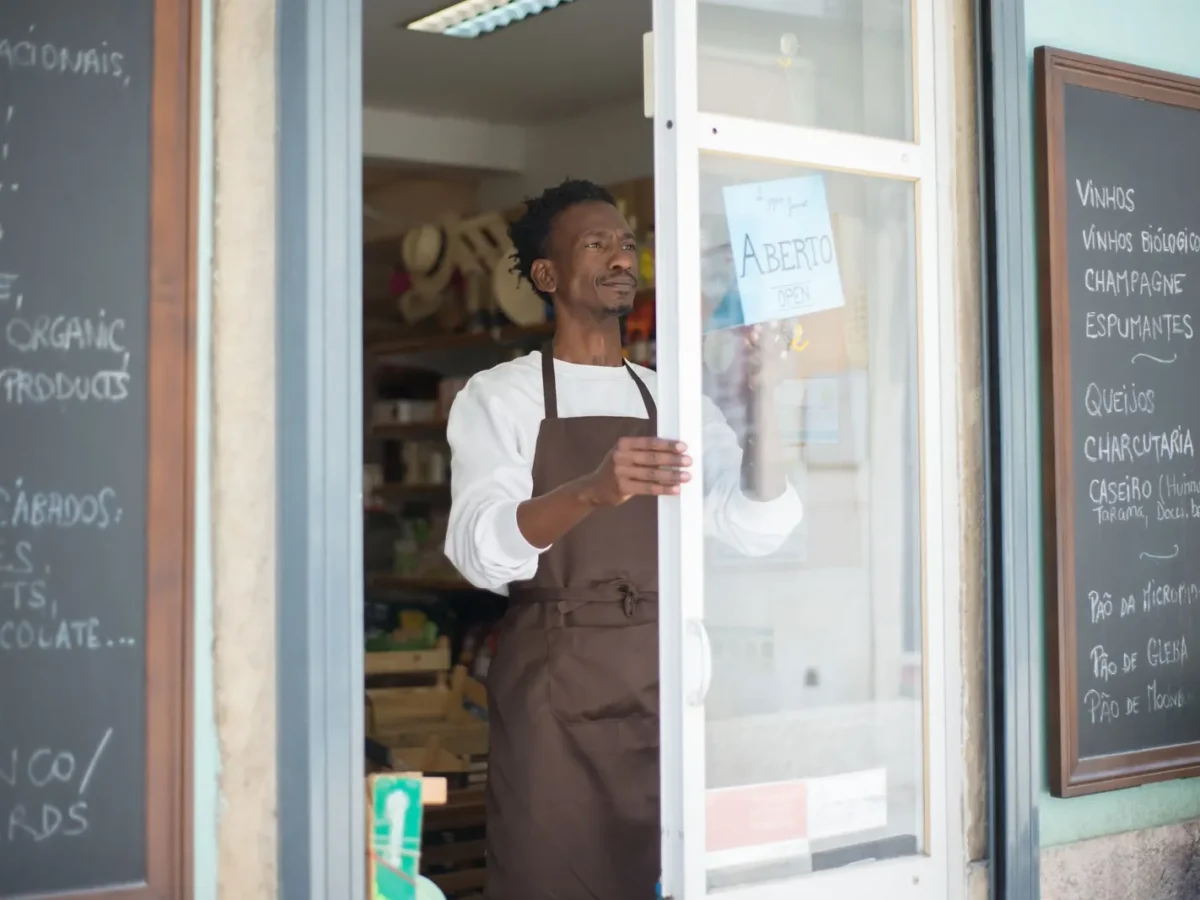 Shop owner opening the front door of a small local store
