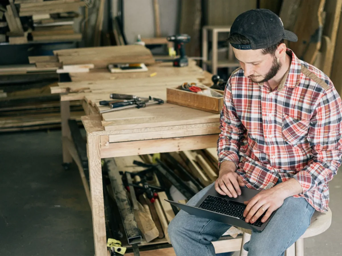 Woodworker using a laptop in his workshop